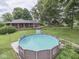 Spacious backyard with above ground pool, patio area and mature trees at 1504 Mcclure Rd, Columbus, IN 47201