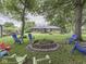 Spacious backyard with green grass, mature trees, brick firepit, and outdoor seating at 1504 Mcclure Rd, Columbus, IN 47201