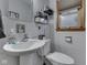 Cozy, tiled bathroom with pedestal sink and decorative mirror at 1504 Mcclure Rd, Columbus, IN 47201
