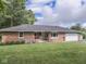 Charming brick ranch home featuring a well-manicured lawn and attached one car garage at 1504 Mcclure Rd, Columbus, IN 47201