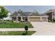 Beautiful home with lush green lawn, mature landscaping, and a three-car garage at 15879 Viking Commander Way, Westfield, IN 46074