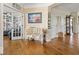 Hallway featuring hardwood floors, stylish decor, and access to an office space with french doors at 15879 Viking Commander Way, Westfield, IN 46074