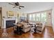 Comfortable living room with fireplace, hardwood floors, plenty of natural light, and ceiling fan at 15879 Viking Commander Way, Westfield, IN 46074