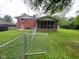 View of the home's backyard and screened-in porch with a chain link fence at 1749 N Graham Ave, Indianapolis, IN 46218