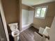 Bathroom featuring a white tub and toilet with a wooden floor at 1749 N Graham Ave, Indianapolis, IN 46218