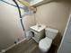 Small basement bathroom with a vanity, toilet, and exposed water pipes at 1749 N Graham Ave, Indianapolis, IN 46218