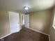 Empty bedroom featuring neutral walls, carpeted flooring, and doors leading to other rooms at 1749 N Graham Ave, Indianapolis, IN 46218