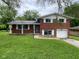 Classic red brick two-story home features an attached garage and spacious front yard at 1749 N Graham Ave, Indianapolis, IN 46218