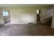 Spacious living room showing staircase and entrances to multiple rooms and neutral carpet at 1749 N Graham Ave, Indianapolis, IN 46218