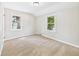 Sunlit bedroom with neutral carpet and two bright windows overlooking the yard at 220 Central Ave, Anderson, IN 46012