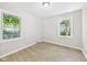 Bedroom with neutral carpet, two windows, and white walls at 220 Central Ave, Anderson, IN 46012