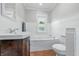 Stylish bathroom featuring a dark wood vanity, white bathtub, and a matching toilet at 2896 Sutherland Ave, Indianapolis, IN 46205