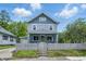 Charming two-story home featuring a fenced front yard, a light blue exterior and a welcoming covered porch at 2896 Sutherland Ave, Indianapolis, IN 46205