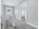 Upstairs hallway with gray carpet leading to a bathroom featuring tile walls and trim at 2896 Sutherland Ave, Indianapolis, IN 46205