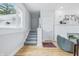 Bright living room featuring a staircase, fireplace with white brick, and hardwood floors at 2896 Sutherland Ave, Indianapolis, IN 46205