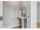 Bright powder room features a pedestal sink, modern faucet, and wood floors at 2896 Sutherland Ave, Indianapolis, IN 46205