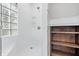 This bright shower features white tiled walls and glass block window, plus a wooden shelving unit at 2896 Sutherland Ave, Indianapolis, IN 46205