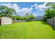 Expansive backyard featuring lush green grass, privacy fence, and a storage shed at 2908 Sherman St, Anderson, IN 46016