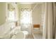 Bathroom featuring neutral tile, shower with curtain, and wood pull-down seat at 2908 Sherman St, Anderson, IN 46016