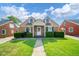 Charming brick home featuring a manicured lawn, tidy bushes, and a sidewalk leading to the front door at 2908 Sherman St, Anderson, IN 46016