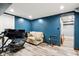 Basement area with dark blue walls, light wood floors and a gaming simulator with a sofa at 2928 Mounds Rd, Anderson, IN 46016