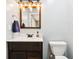 Bathroom featuring a dark vanity with white countertop, mirror, sink, and toilet at 2928 Mounds Rd, Anderson, IN 46016