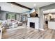 Open living room boasts a decorative fireplace, wood floors, and comfortable seating area at 2928 Mounds Rd, Anderson, IN 46016