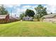 Large fenced in backyard with lush green grass and shade trees that includes a large deck and well maintained home at 2928 Mounds Rd, Anderson, IN 46016
