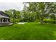 Spacious backyard with lush lawn, mature trees, inviting patio, and a sparkling pool at 3549 W 131St St, Carmel, IN 46032