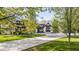 A striking two-story residence features a long driveway flanked by mature trees and professionally landscaped grounds at 3549 W 131St St, Carmel, IN 46032