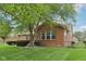 Spacious backyard featuring lush lawn, mature shade trees, brick exterior, and outdoor living space at 3571 S Cedar Creek Ln, New Palestine, IN 46163