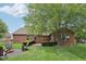 Expansive backyard features lush greenery, a fire pit with Adirondack chairs, and a brick home exterior at 3571 S Cedar Creek Ln, New Palestine, IN 46163