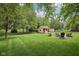 Well-manicured backyard features a fire pit area with seating, storage shed, and mature shade trees at 3571 S Cedar Creek Ln, New Palestine, IN 46163