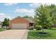 Charming brick home featuring a two-car garage, well-manicured lawn, and mature landscaping at 3571 S Cedar Creek Ln, New Palestine, IN 46163