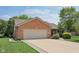 Attached two-car garage and manicured landscaping enhance the curb appeal of this brick home at 3571 S Cedar Creek Ln, New Palestine, IN 46163