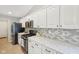 Modern kitchen with white cabinets, stainless steel appliances, and granite countertops at 3571 S Cedar Creek Ln, New Palestine, IN 46163