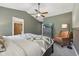 Main bedroom with a ceiling fan, dresser, chair, doorway leading to a bathroom, and large bed at 3571 S Cedar Creek Ln, New Palestine, IN 46163