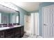 Bathroom with double sinks, vanity, framed mirror, walk-in shower with curtain and grey rug at 4353 W Parkway Ct, New Palestine, IN 46163