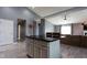 Open concept kitchen island with dark granite countertop, white cabinets and seating at 4353 W Parkway Ct, New Palestine, IN 46163