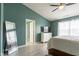 Bright main bedroom featuring vaulted ceilings, a ceiling fan, and a full-length mirror at 4353 W Parkway Ct, New Palestine, IN 46163