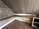 Attic space featuring sloped ceilings, hardwood floor, built-in shelving, and natural light at 4709 E New York St, Indianapolis, IN 46201