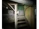View of wooden basement stairs leading up, with exposed brick walls at 4709 E New York St, Indianapolis, IN 46201