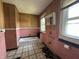 Outdated bathroom featuring a tub, pink tile, and wood paneling; needs remodeling at 4709 E New York St, Indianapolis, IN 46201