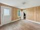 Empty bedroom featuring hardwood floors, wood-paneled walls, and white trim at 4709 E New York St, Indianapolis, IN 46201