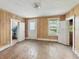 Empty bedroom with hardwood floors, wood-paneled walls, and multiple windows at 4709 E New York St, Indianapolis, IN 46201
