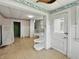 Eat-in kitchen with white cabinets, shelving and an adjoining stairwell at 4709 E New York St, Indianapolis, IN 46201