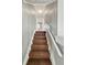 View looking up staircase covered in brown carpet with white banister and wall paneling at 4709 E New York St, Indianapolis, IN 46201