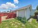 Backyard with a detached garage with a small deck, green grass, and red fence at 4715 E New York St, Indianapolis, IN 46201