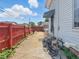Cozy backyard featuring a red fence, concrete patio and stairs to the back entrance at 4715 E New York St, Indianapolis, IN 46201