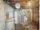 Unfinished basement utility area showing water heater, boiler, and plumbing fixtures at 4715 E New York St, Indianapolis, IN 46201